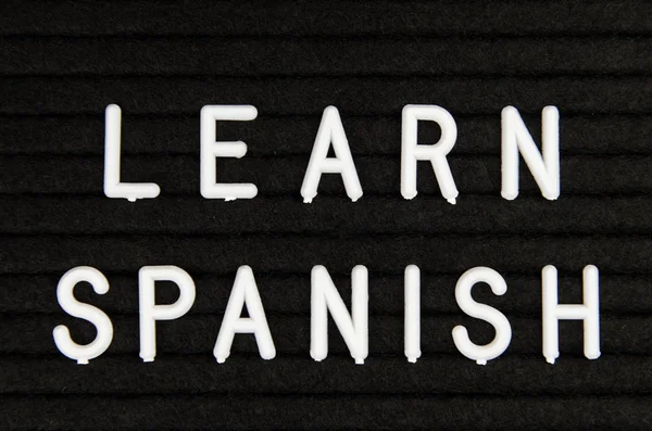 Learn Spanish sign on black background