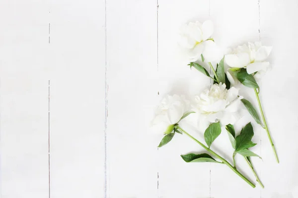 Foto de estoque estilo. Composição da mesa de casamento feminino com flores de peônias brancas no fundo de madeira branco velho. Um espaço vazio. Vista superior. Imagem para blog . — Fotografia de Stock