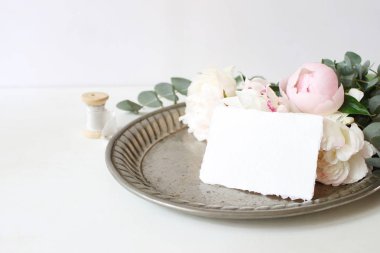 Kadınsı düğün ya da Doğum günü tablo ile kompozisyon çiçek buketi. Beyaz ve pembe peonies çiçek ve okaliptüs dallarda eski vintage gümüş tepsi, craft kağıt kartı ve ipek kurdele.