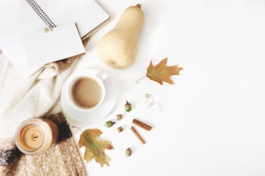 Kompozisyon tarz kadınsı düşmek. Sonbahar çalışma alanı natürmort. Fincan kahve, yün battaniye, sonbahar yaprakları ve kabak ile defter mock-up sahne. Beyaz masa artalanını. Düz yatıyordu, en iyi görünümü.
