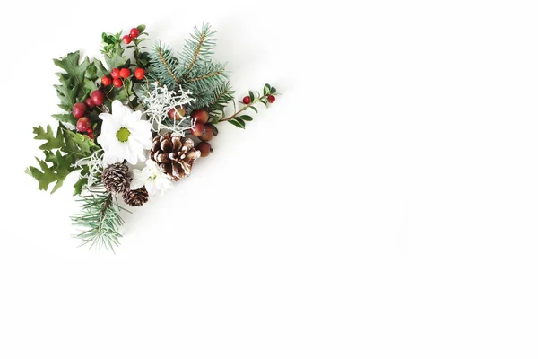 Christmas festliga blommig sammansättning. Kottar, fir, trädgrenar, Eklöv, röda Rönnbär och krysantemum blommor på vitt bordsbakgrund. Dekorativa hörn. Platt lekmanna, top view. — Stockfoto