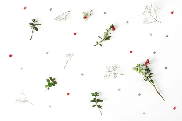 Christmas blommönster. Vinter sammansättning av röda tranbär grenar, babys andedräkt blommor och silver konfetti stjärnor på vitt bord. Festlig bakgrund. Platt lekmanna, top view. — Stockfoto