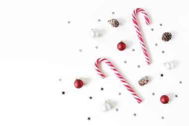 Noel kompozisyon tarz. Christmas kırmızı ve beyaz top, baubles, köpekler, gümüş yıldız konfeti dekorasyon ve karaçam koniler beyaz arka plan üzerinde pırıltılı şeker. Düz yatıyordu, en iyi görünüm. Kış patttern.