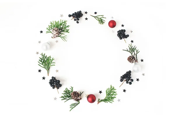 Christmas circle blommig sammansättning. Krans av gröna cypress grenar, lärkträd kottar, julgranskulor glas, grannlåt, silver konfetti stjärnor och svart privet, bär. Vitt bordsbakgrund. Flatlay — Stockfoto