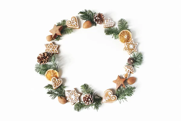 Christmas circle blommig sammansättning. Krans av fir tree grenar, kottar, pepparkakor och torka apelsinskivor på vit bakgrund. Vinter semester design. Platt lekmanna, top view. — Stockfoto