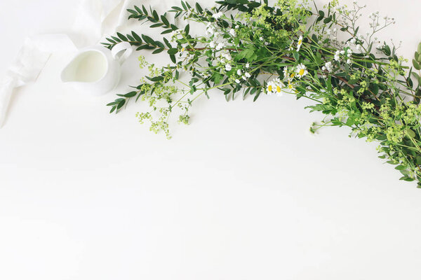 Праздничная свадьба, сцена за праздничным столом с эвкалиптовой парвифолией, шелковая лента, цветы дикого луга и молочный кувшин на белом фоне. Сельский женский дизайн. Квартира лежала, вид сверху. Пустое пространство
.