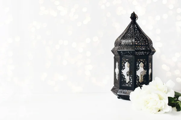 Ornamental oscuro marroquí, linterna árabe con flores de peonía en la mesa blanca y luces bokeh brillante. Tarjeta de felicitación para la comunidad musulmana mes santo Ramadán Kareem. Fondo festivo . — Foto de Stock