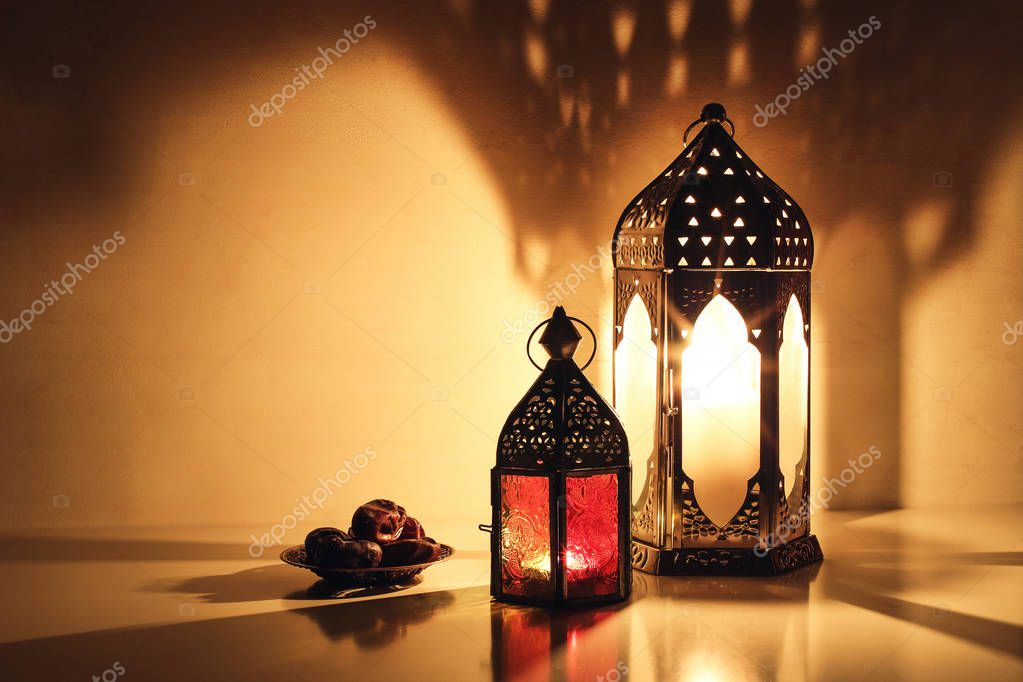 Faroles árabes ornamentales con velas encendidas que brillan por la