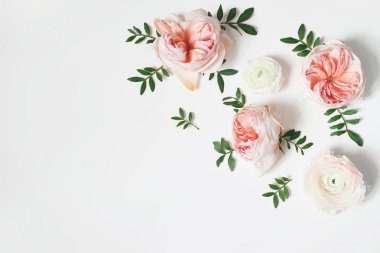 Dekoratif köşe, pembe İngilizce gül, tipik ve yeşil ile çiçek kompozisyon beyaz masa arka plan üzerinde bırakır. Çiçek deseni. Düz yatıyordu, en iyi görünüm. Düğün ya da doğum günü hazır fotoğraf haberi.