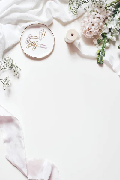 Våren, bröllop stilleben scen. Bukett av hyacint, babys andedräkt Gypsophila och grekisk blommor på vitt bordsbakgrund. Tavla med rosa och golden Gem. Vertikal platta lekmanna, top view. — Stockfoto