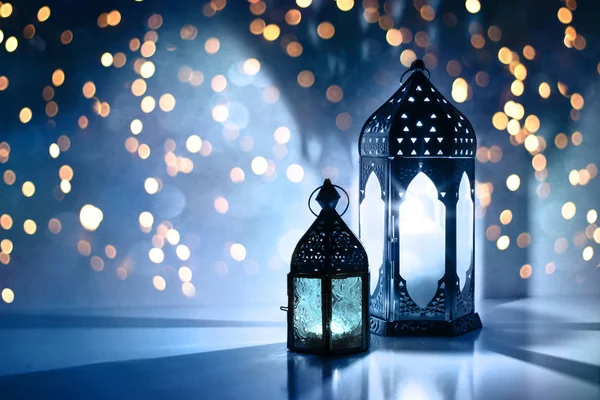 Couple of glowing Moroccan ornamental lanterns on the table. Greeting card, invitation for Muslim holy month Ramadan Kareem. Festive blue night background with glittering golden bokeh lights. — Stock Photo, Image