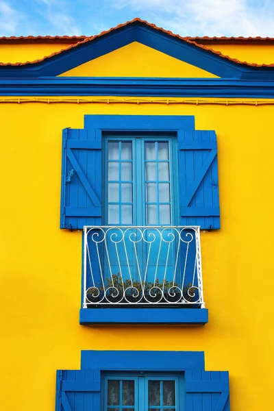 Színes portugál sárga ház homlokzat, régi kék ablakok és fából készült redőnyök, Portugália város closeup, Európa. Utazási és építészeti koncepció. Függőleges. — Stock Fotó