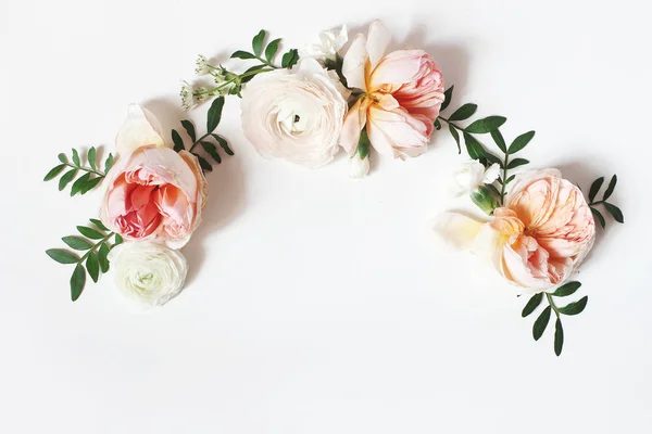 Dekoratif çelenk, çiçek çelenk, pembe İngiliz gül, ranunculus ve beyaz masa arka plan üzerinde yeşil yaprakları ile kompozisyon. Çiçek deseni. Düz yatıyordu, üstten bak. Düğün, doğum günü tarzı stok fotoğraf. — Stok fotoğraf