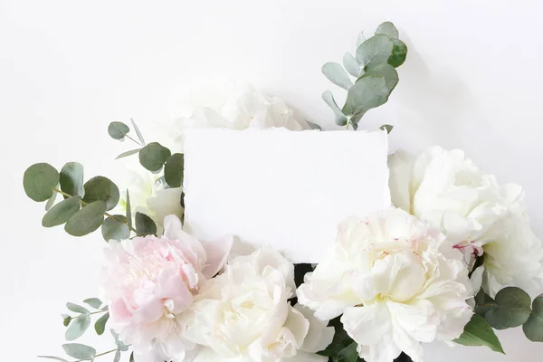 Kadındüğünü, doğum günü makyaj sahnesi. Boş pamuklu kağıt kart, davetiye ve çiçek buketi yakın çekim. Beyaz ve pembe şakayık çiçekler ve okaliptüs. Tarz stok fotoğraf. — Stok fotoğraf