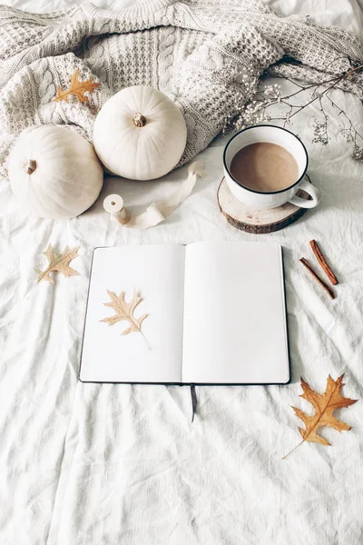 Colazione autunnale nella composizione a letto. Mockup del taccuino vuoto aperto. Tazza di caffè, zucche bianche, maglione, foglie di quercia e cannella su fondo lino. Ringraziamento, Halloween. Piatto. Vista dall'alto — Foto Stock