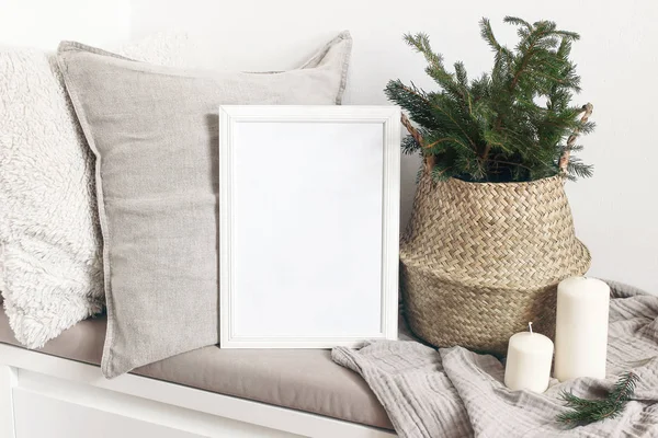 Fehér üres fa keret mockup karácsonyfa, gyertyák, vászon párnák és kockás a fehér padon. Plakáttervezés. Skandináv lakberendezés, skandináv design. Téli ünnepi koncepció. — Stock Fotó