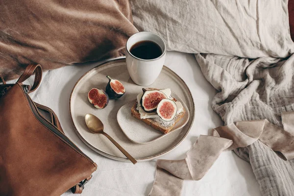 Autunno natura morta colazione. Panino al pane con formaggio e fico affettato, borsa in pelle e tazzina di caffè su fondo lino bianco. Cuscini in velluto e lino a letto. Ringraziamento, concetto autunnale. Vista dall'alto. — Foto Stock