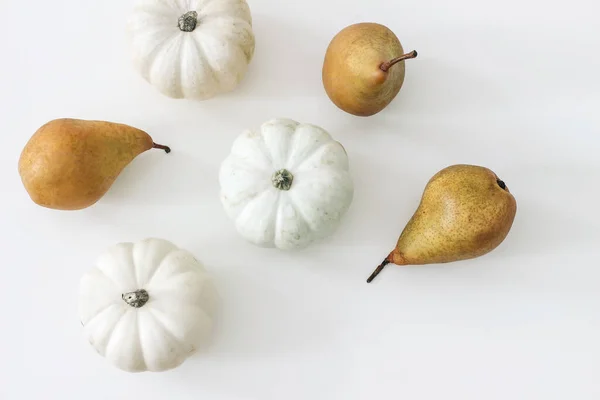 秋の収穫パターン、ウェブバナー。白いテーブルの背景に隔離された梨の果実と白いカボチャ。秋、感謝祭のデザイン。フラットレイアウト、トップビュー。園芸作物. — ストック写真