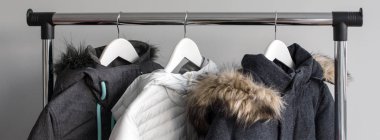 Sıcak ceket askı standı. Kış ceket kürk yakalı Beyaz ahşap askı asmak. Kış ceket dükkanda topluluğu. Kış sezon moda arka plan.