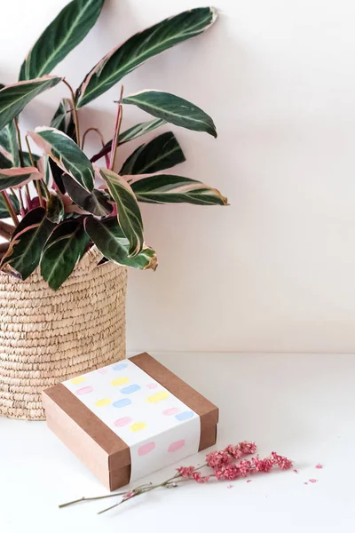 Caja de regalo de papel artesanal marrón con flores en mesa blanca. Enfoque selectivo . — Foto de Stock