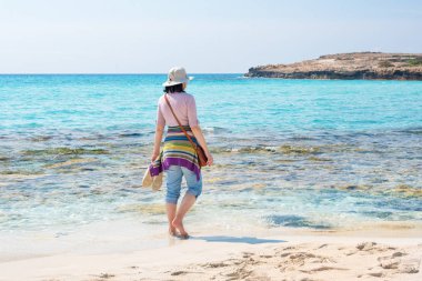Şapka sahilde yalınayak kadında. Yaz tatili, tatil, seyahat ve kavramı kişi