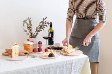 Paskalya pastasını kadınların elinde kes. Geleneksel Paskalya ortodoks tatlı ekmeği, Kulich. Paskalya kahvaltısı. Paskalya pastası kesen kadın.