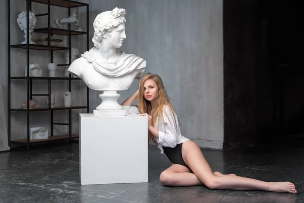 Tanrı Apollo 'nun yanında oturan genç yarı çıplak kadın heykeli. Güneş ve şiir antik Yunan tanrısı Grange beton duvar arka planda bir mermer heykel kopya. Antik Sanat ve yaşam güzelliği — Stok fotoğraf