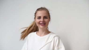 Sevimli kadın 20s etrafında oynarken ve onu sarı saç sallayarak portresi. Duygular kavramı