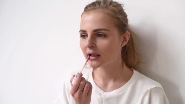 Close-up weergave van een jonge vrouw toepassing van lippenstift op haar lippen — Stockvideo