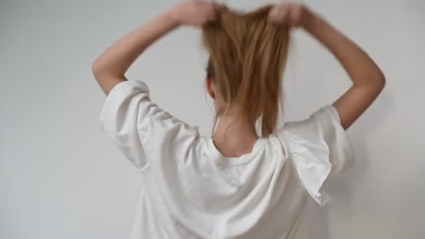 Retrato de una linda mujer de 20 años jugando y sacudiendo su cabello rubio, cámara lenta. Concepto de emociones — Vídeo de stock