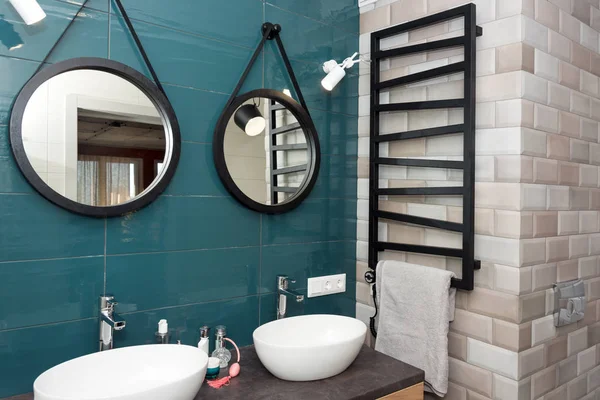Сучасний інтер'єр ванної кімнати з дерев'яною полицею, двома раковинами, що стоять на ній і круглими дзеркалами. Прозора скляна душова кабіна, мінімалістична скандинавська ванна в квартирі лофт — стокове фото