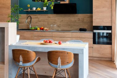 Lüks mutfakta modern mobilyalar. Minimalist İskandinav iç mimarisi, ahşap mobilyalar, lambalar, beton elementler ve bitkilerle dolu bir çatı katında.