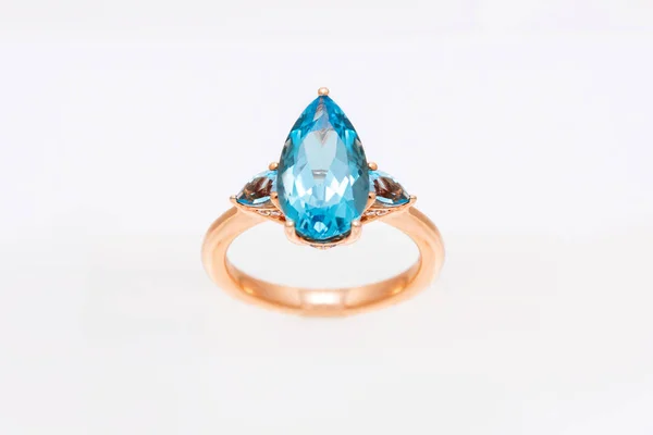 Anello diamante con gemme preziose blu. Anello giallo oro su sfondo chiaro. Accessori di lusso moda — Foto Stock