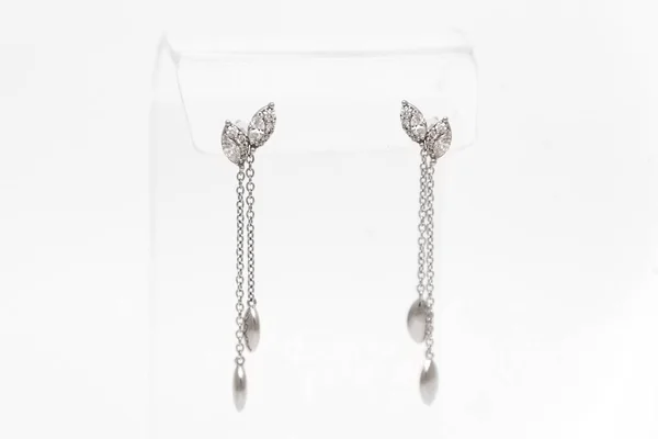 Paar witte gouden diamanten oorbellen op transparante stand. Gouden oorbellen met diamanten, luxe sieraden — Stockfoto