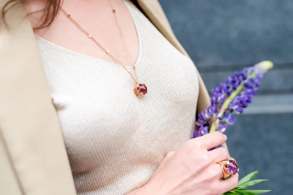 People, fashion, jewelry and luxury concept, closeup of woman wearing luxury jewelry standing on the street. Color gemstone ring and pendant with colored diamonds and gemstones — Stock Photo, Image