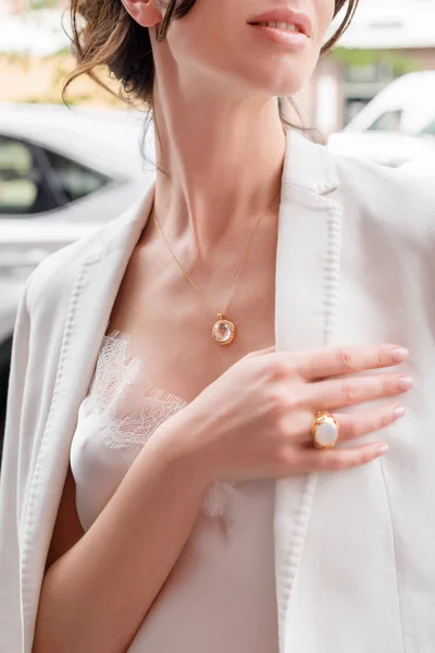 People, fashion, jewelry and luxury concept, closeup of woman wearing luxury jewelry standing near expensive car on the street. Color gemstone ring and pendant with colored diamonds and gemstones — Stock Photo, Image