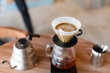 Kafede ahşap masa üzerinde kahve demleme gadget'lar Closeup. Damla demleme, filtrelenmiş kahve veya dökme-over kavrulmuş üzerine su dökme içeren bir yöntemdir, bir filtre bulunan öğütülmüş kahve çekirdekleri