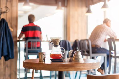 Kafede ahşap masa üzerinde kahve demleme gadget'lar Closeup. Damla demleme, filtrelenmiş kahve veya dökme-over kavrulmuş üzerine su dökme içeren bir yöntemdir, bir filtre bulunan öğütülmüş kahve çekirdekleri