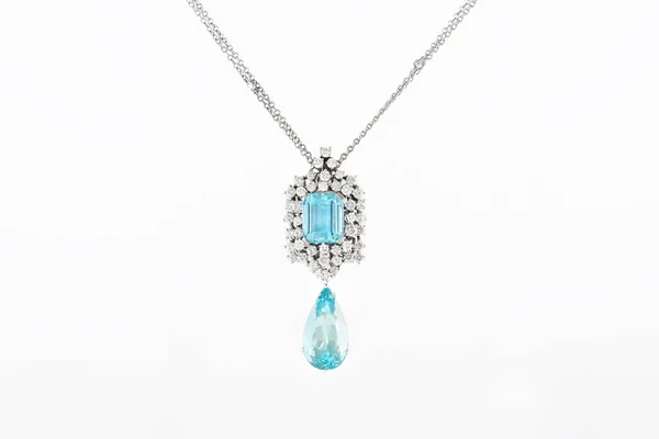 Luxury white golden pendant with blue gemstone and diamonds on stand. — Stock Photo, Image