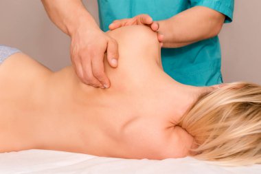 Kadın kiropraktik sırt düzeltmesi yaptırıyor. Osteopati, alternatif tıp, ağrı kesici konsepti. Klinikte hastayla çalışan bir fizyoterapist. Fizyoterapi, spor sakatlığı rehabilitasyonu.