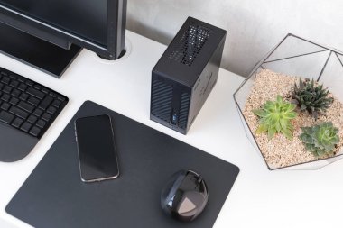 Modern ofisin içinde. Klavyeli, fareli, telefonlu ve sulu beyaz masalı bir yer. Şık minimalist çalışma alanı, serbest çalışan çalışma alanı. Kopyalama alanı olan üst görünüm, düz yatay