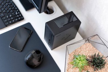 Modern ofisin içinde. Klavyeli, fareli, telefonlu ve sulu beyaz masalı bir yer. Şık minimalist çalışma alanı, serbest çalışan çalışma alanı. Kopyalama alanı olan üst görünüm, düz yatay