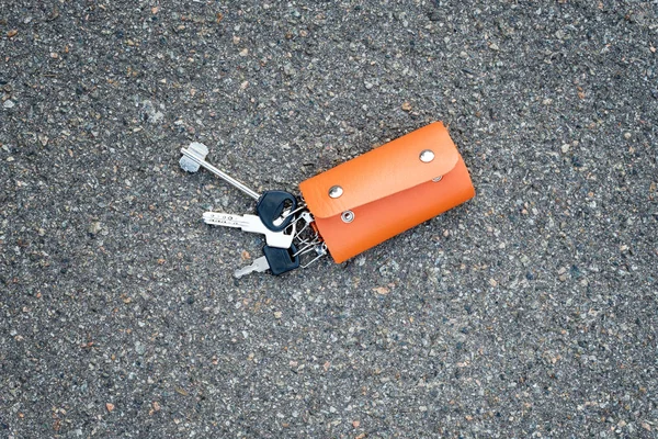 Um monte de chaves numa caixa de couro deitada no chão. Chaves no partholme de couro foram perdidos ou encontrados . — Fotografia de Stock