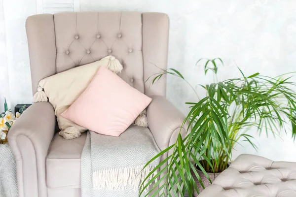 Stijlvolle beige fauteuil met roze kussens in een licht minimalistisch interieur — Stockfoto