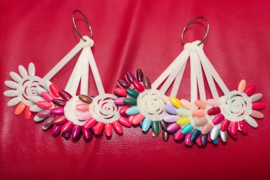 Oje farklı swatches ile Palet. Manikür için vernik örnekleri renkli koleksiyonu. Kırmızı deri arka plan üzerinde tırnak sanat tasarım örnekleri