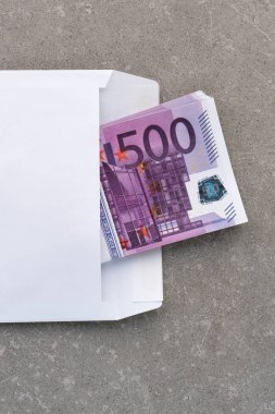 İçinde 500 Euro banknotlar olan beyaz bir zarf. Betonun üzerindeki açık posta zarfında 500 avroluk banknot yığını. Banknotlar hediye olarak bir zarfın içinde katlandı. Para göndermek veya biriktirmek, yolsuzluk kavramı