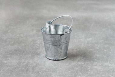 Beton bir arka planda izole küçük metal kova boş. alanı kopyalayın. Yatay görünüm.