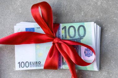 Kırmızı kurdeleli bir desteye 100 euro. Hediye, ikramiye veya ödül konsepti