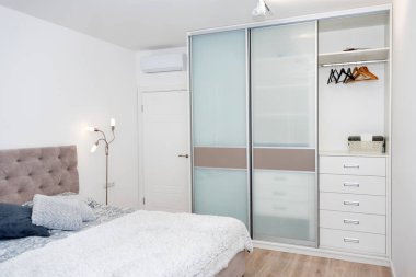 Renkli yastıkları, yatak örtüsü ve rahat bir lambası olan bir yatağı kapat. Çatı katı, minimalist İskandinav tarzı..