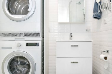 Modern banyo içi. Şeffaf cam duş kabini, çamaşır kurutma makinesi, çatı katında minimalist hafif İskandinav banyosu.